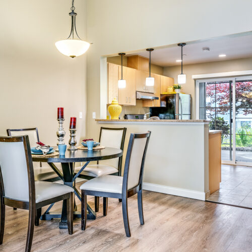 Model room with full kitchen and dining table nearby