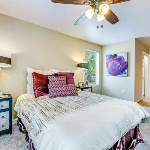 Bedroom in the cottage with large queen bed and entrance to bathroom