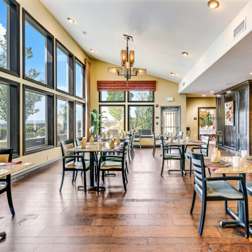 Cozy, elegant dining room with vaulted ceilings and floor to ceiling windows